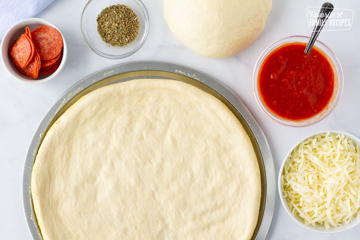 Roll out of Homemade Pizza Dough next to toppings.