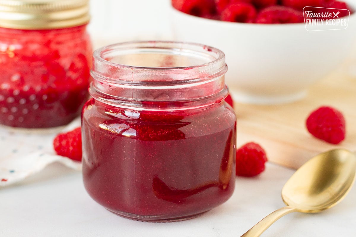 Side view of raspberry coulis in a jar.