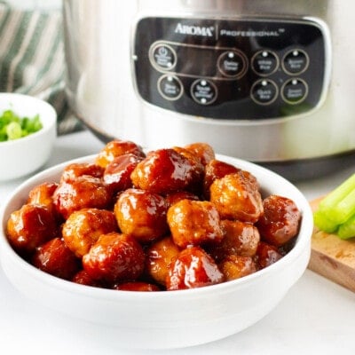 Cocktail Meatballs in a bowl next to slow cooker, sliced celery and green onions.