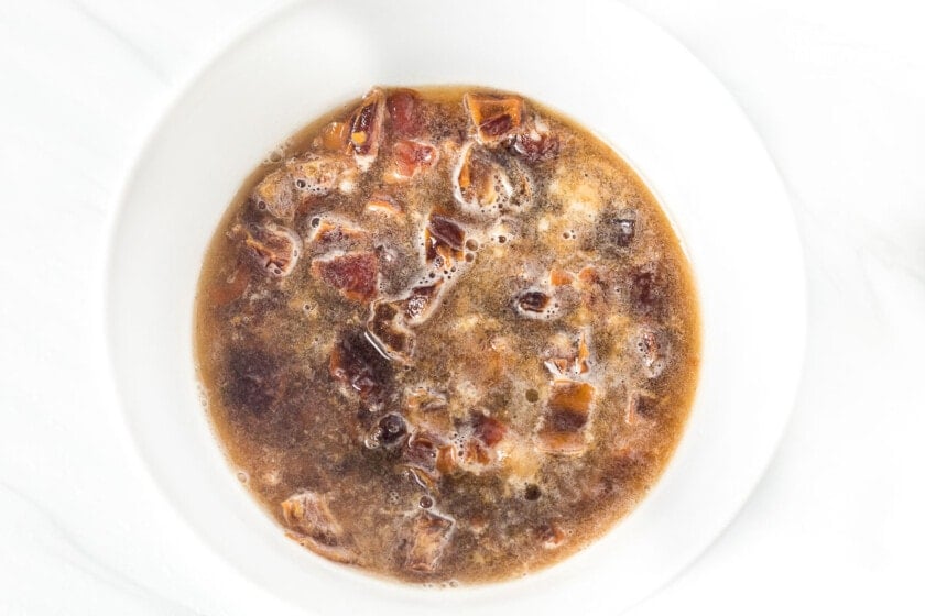 Chopped dates soaking in water and baking soda in a small bowl