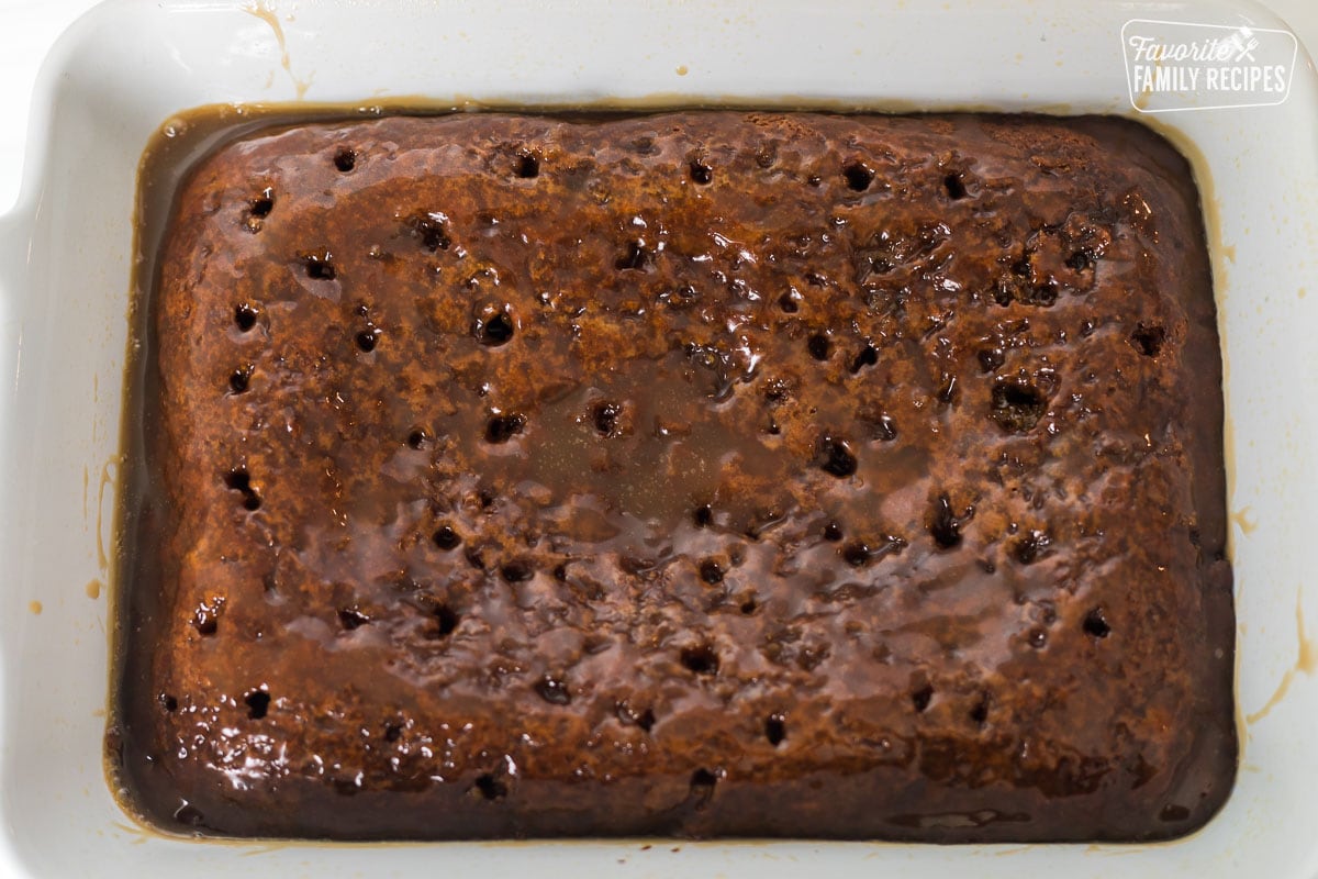 A cake pan with a sticky toffee sponge with sauce over the top