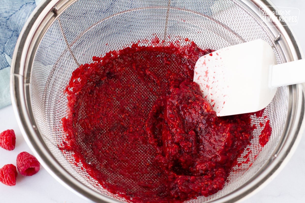 Raspberry pulp and seeds in a strainer for Raspberry Cheesecake sauce.
