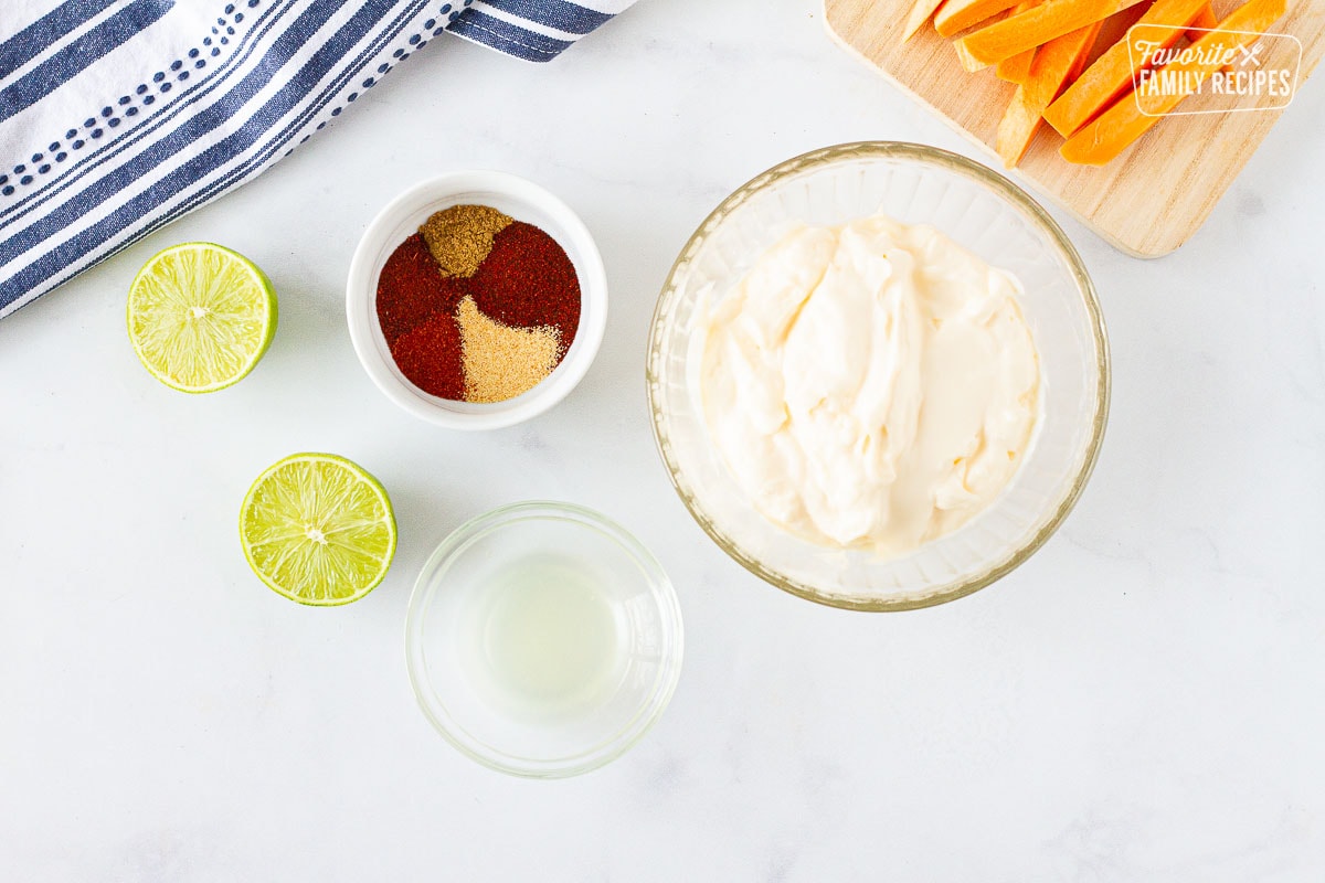 Mayo, spices, lime juice to make Sweet Potato Fries Dipping Sauce. Cutting board with sliced sweet potatoes.