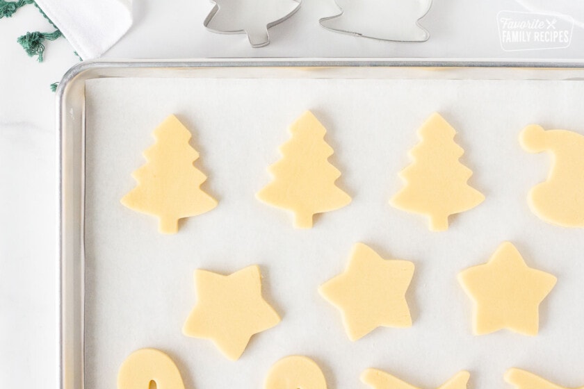 Baking sheet of unbaked cut out Christmas Sugar Cookies.