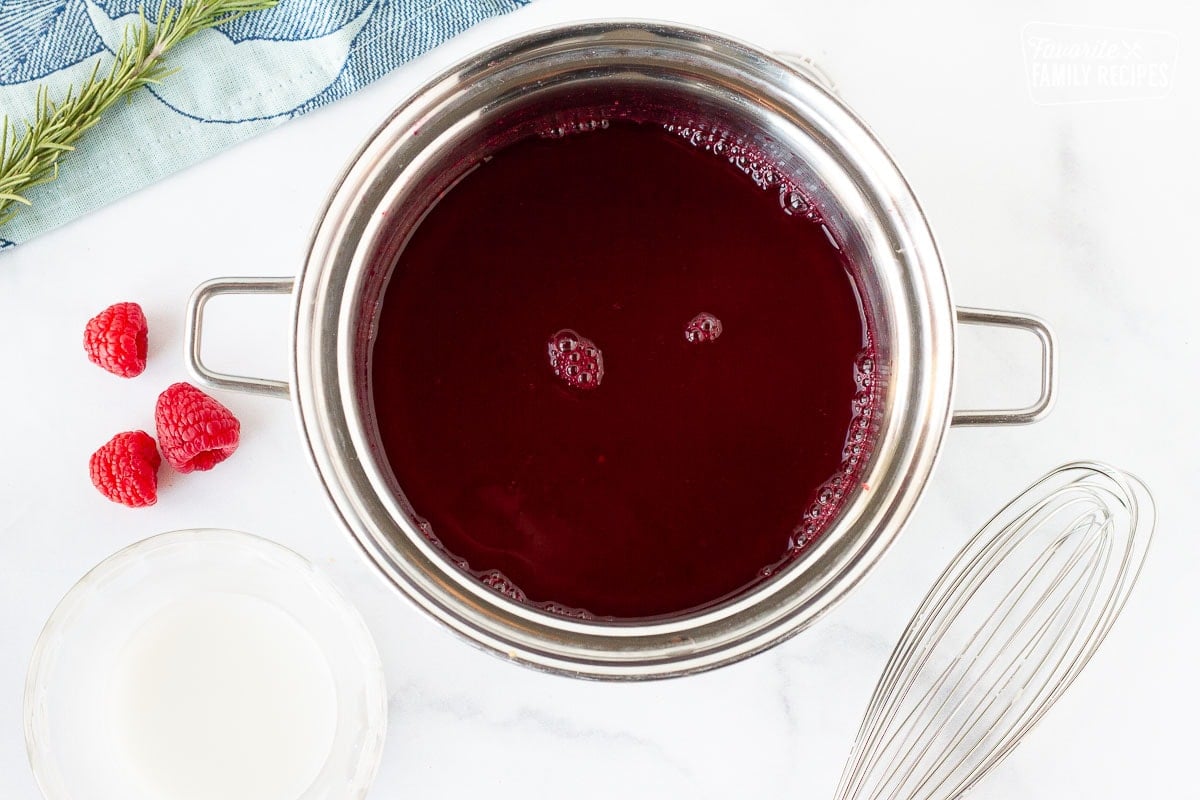 Pot of Raspberry Cheesecake sauce, cornstarch slurry on the side.