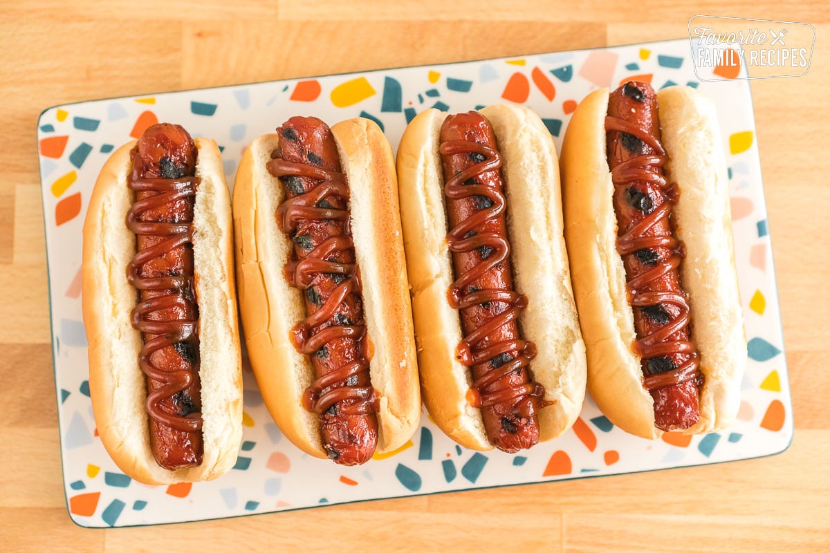 Four hot dogs in buns on a plate