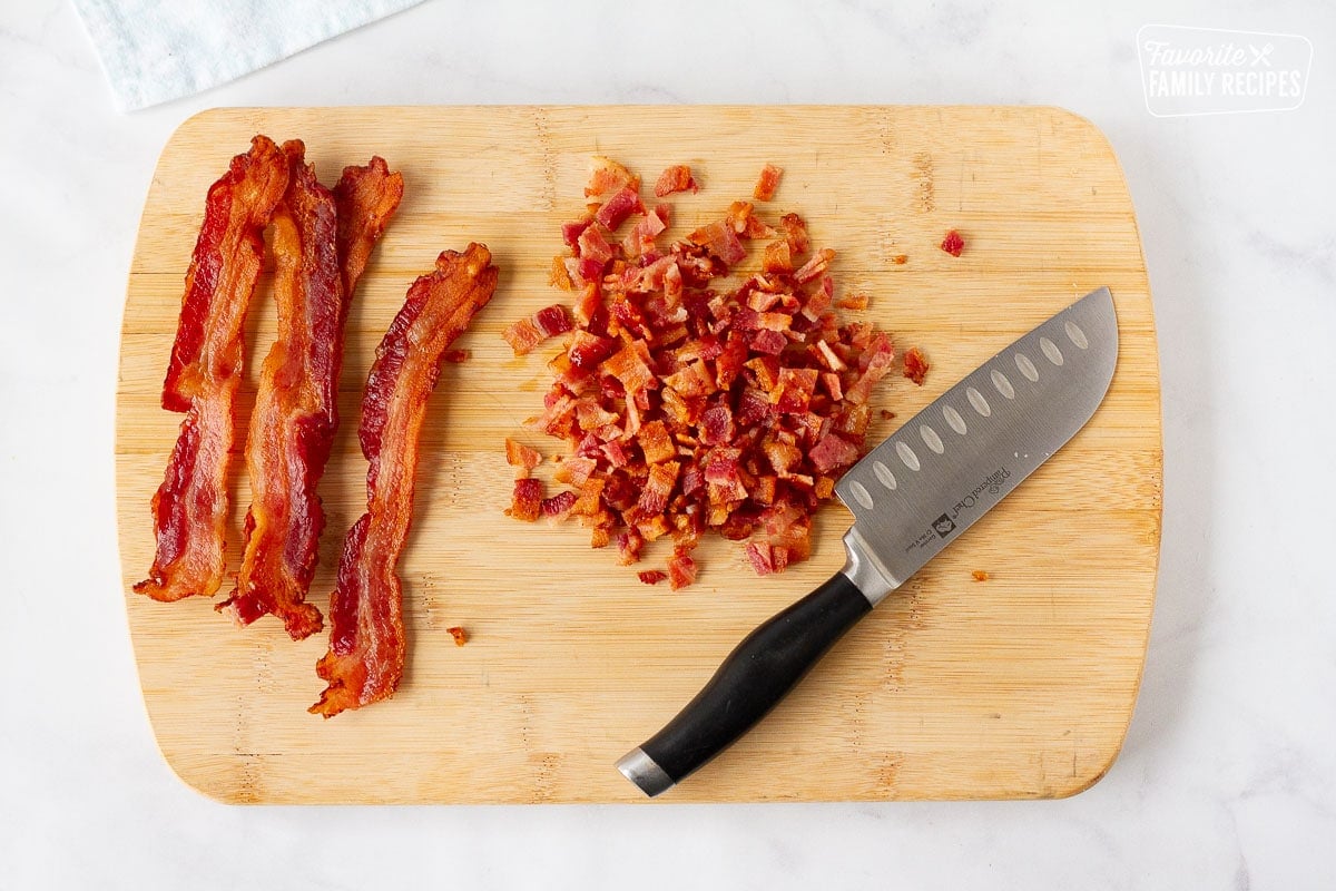 Cutting board with chopped bacon and a knife for Corn Chowder.