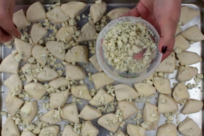 Blue cheese sprinkled over biscuit dough for Blue Cheese Bombs.