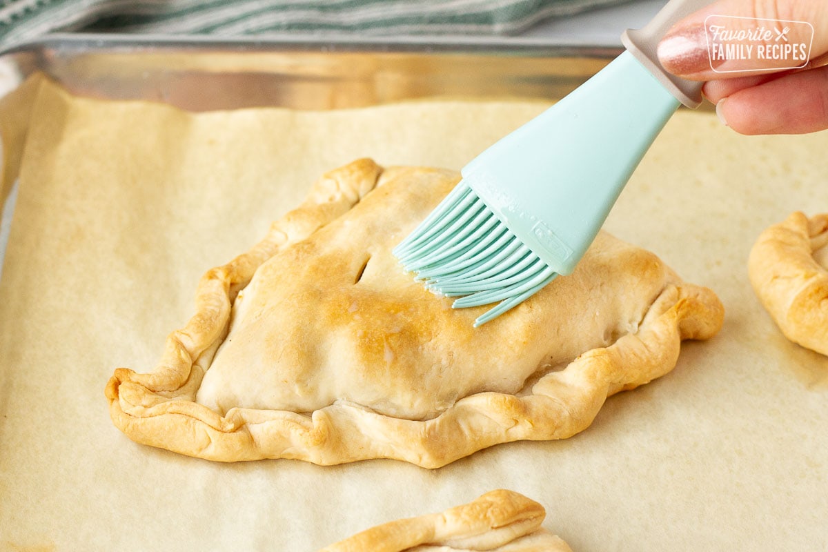 Brushing butter on the top of a baked Donovan's Irish Pastie.