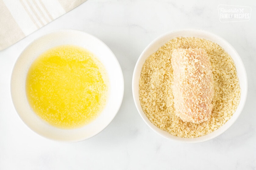 One bowl of melted butter and one bowl of a rolled up chicken breast covered in panko for Instant Pot Chicken Cordon Bleu.