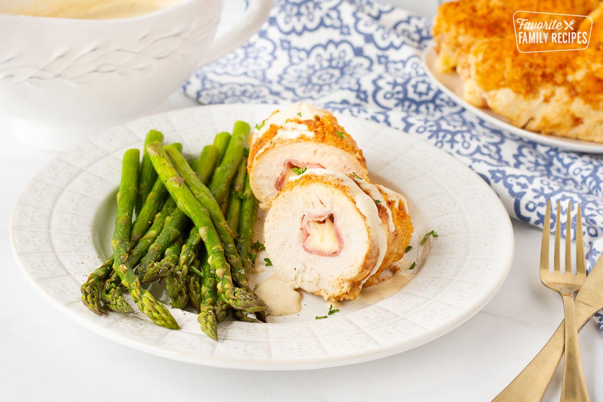 Chicken Cordon Bleu cut in half covered with sauce.