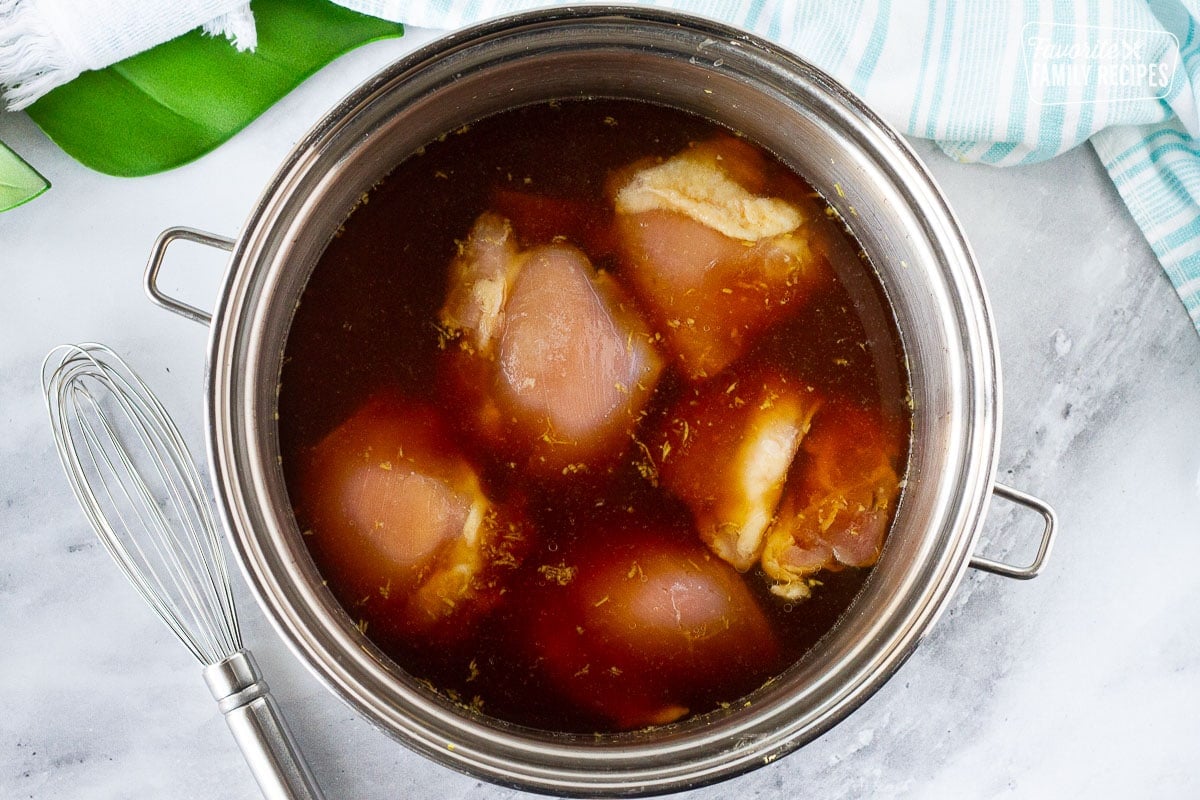 Pot of broth with chicken thighs for Hawaiian Style Chicken Long Rice Noodles.