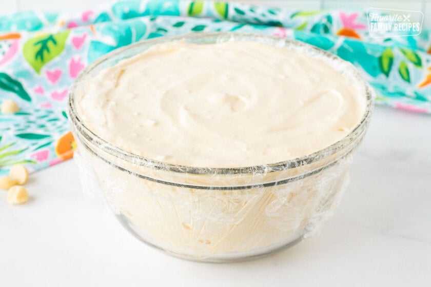 Bowl lined with plastic wrap filled with coconut macadamia nut ice cream for Duke's Hula Pie.