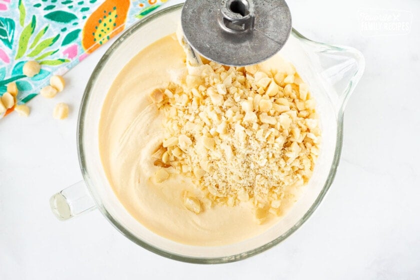 Mixing bowl with ice cream and macadamia nuts on top with mixing hook for Duke's Hula Pie.