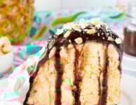 Plate with Duke's Hula Pie with whipped cream, fudge sauce and chopped macadamia nuts.