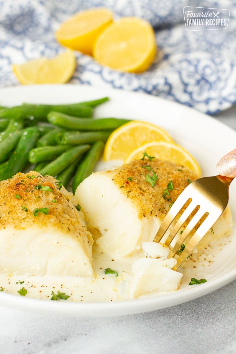 Fork cutting into a fillet of Baked Cod in Cream Sauce.