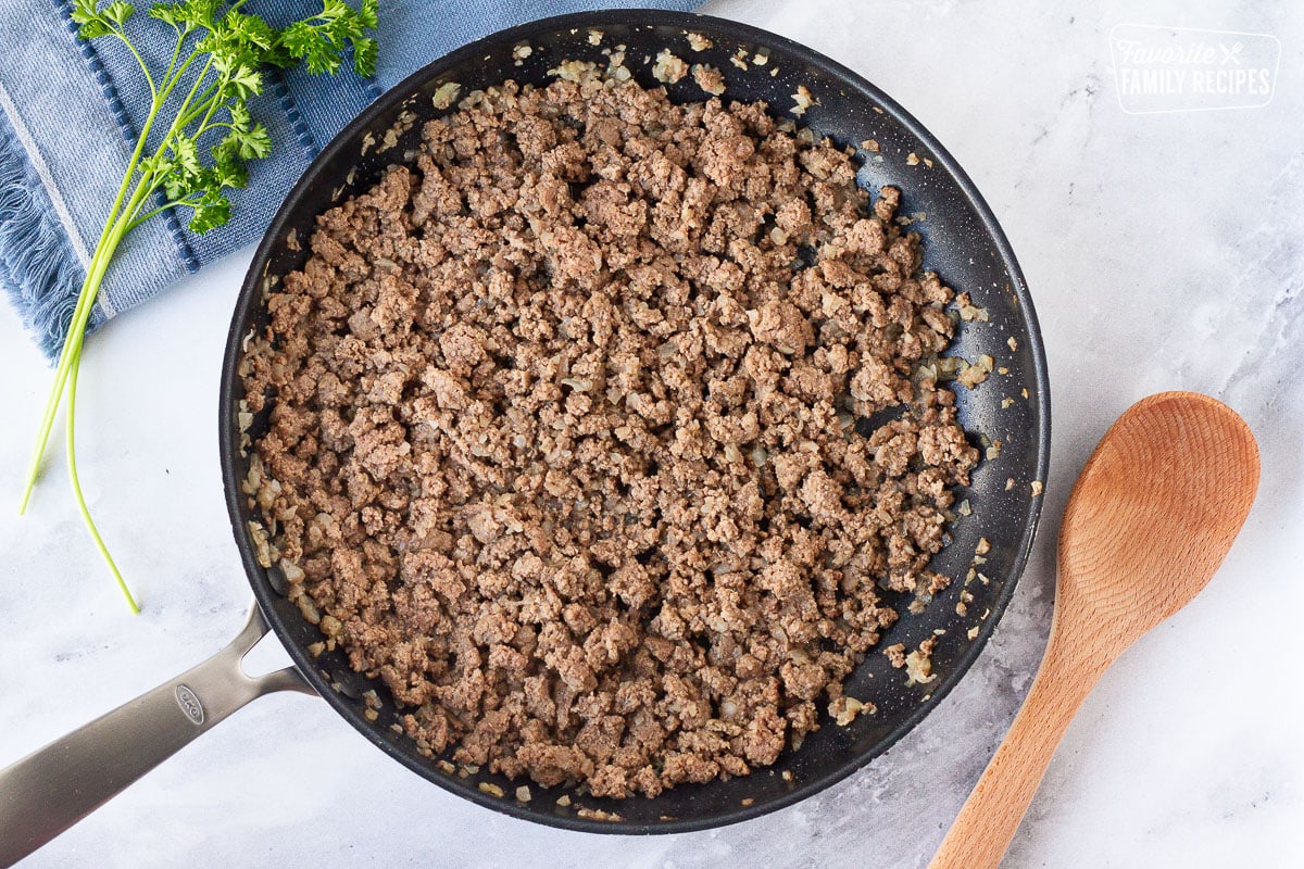 Ground beef and onions in a skillet to make Creamy Ground Beef and Noodles Skillet.