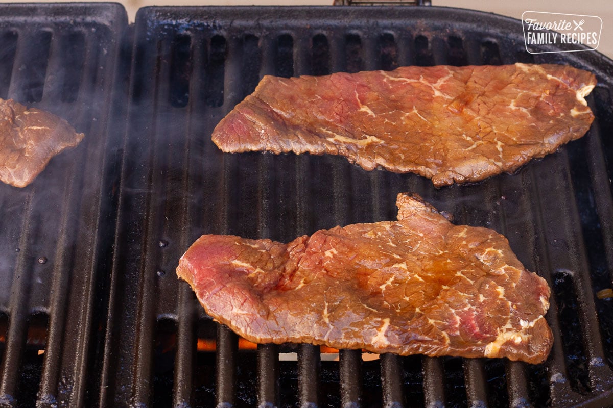 Two Hawaiian Beef Teriyaki steaks grilling on the BBQ.