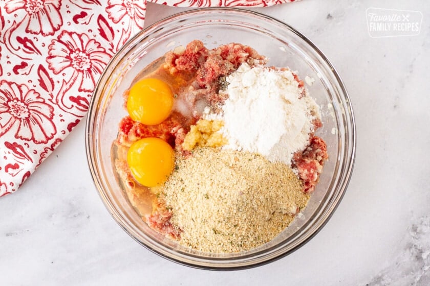 Bowl of ground meat, eggs, bread crumbs, garlic, salt, pepper and flour for Frikadeller (Danish Meatballs).