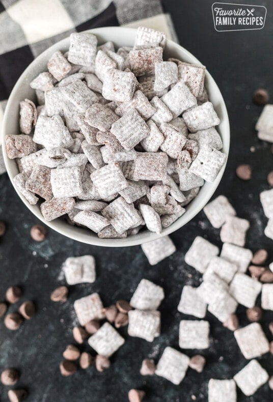 A bowl of muddy buddies on a black counter top