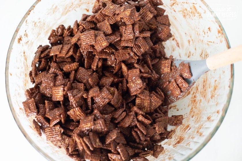 Melted chocolate being stirred together with Chex