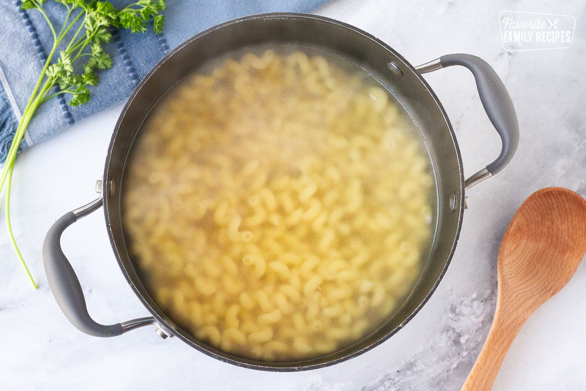 Cooked noodles in a pot of water for Creamy Ground Beef and Noodles Skillet.