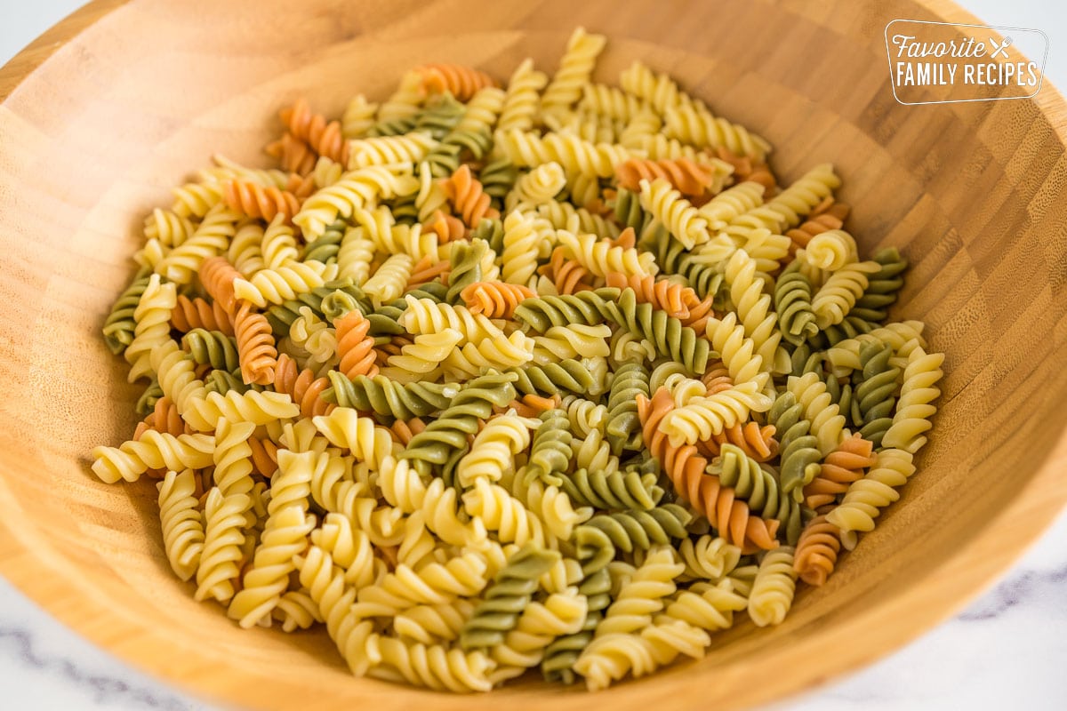 tri-color rotini in a large wooden bowl