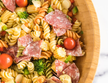 A large wooden bowl full of pasta salad