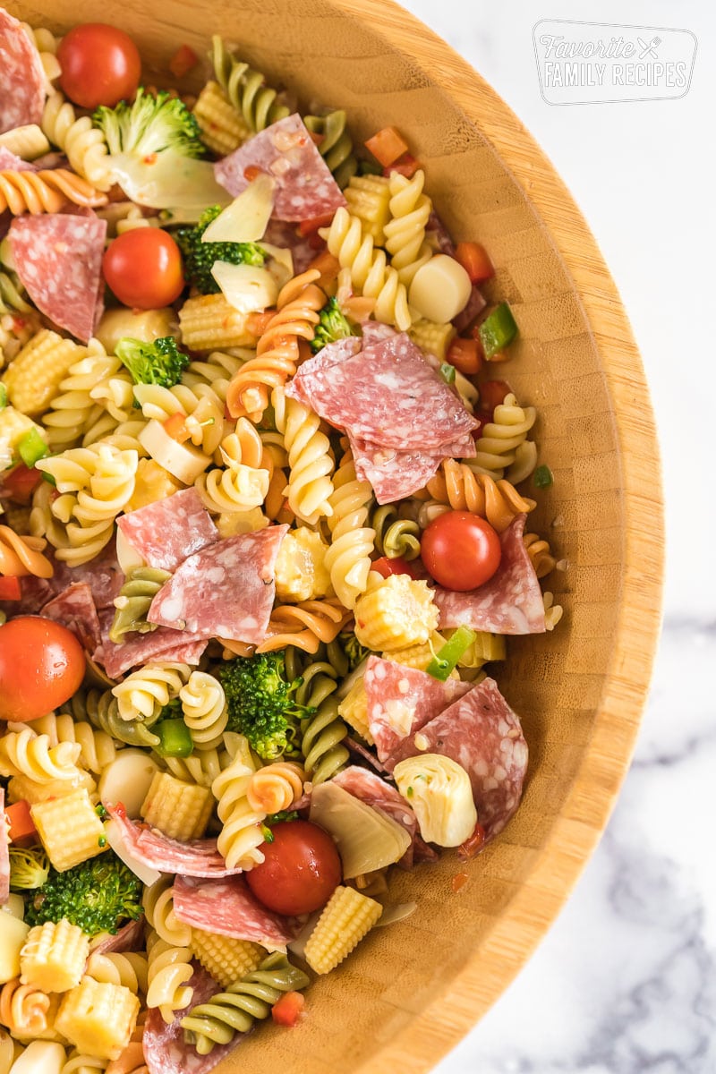 A large wooden bowl full of pasta salad