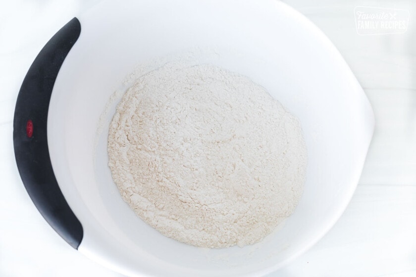 Flour and dry ingredients in a bowl to make peanut butter blossoms