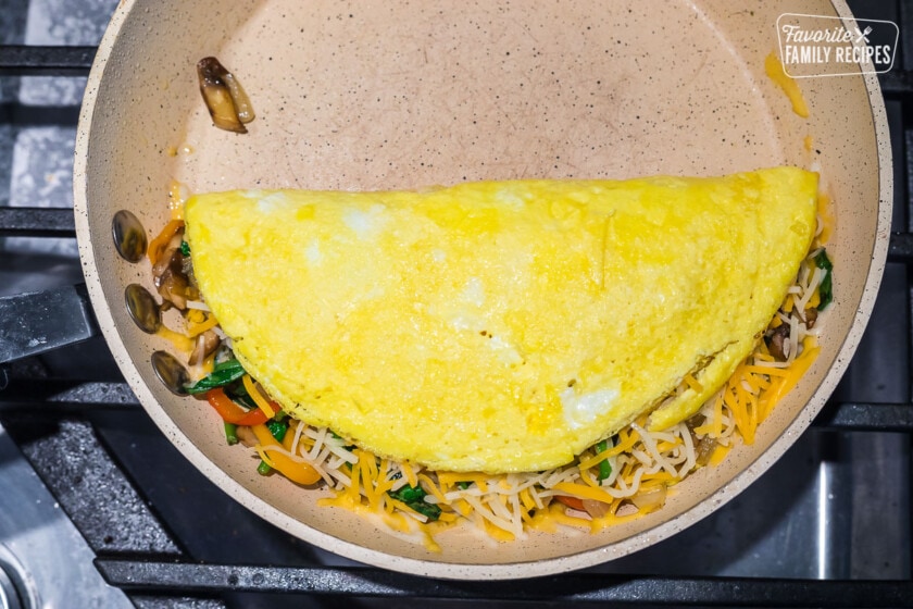 A veggie omelette folded over in a pan.