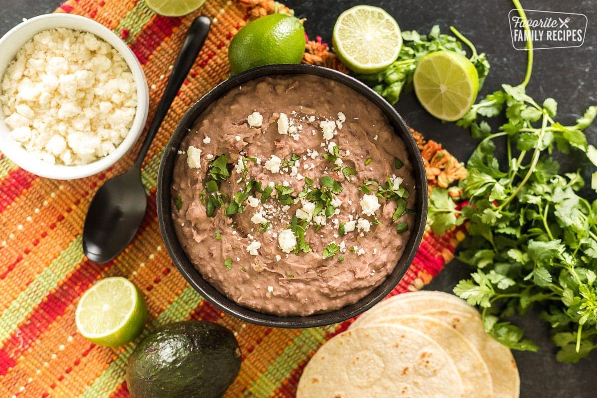 A bowl of refried beans on a colorful placemat