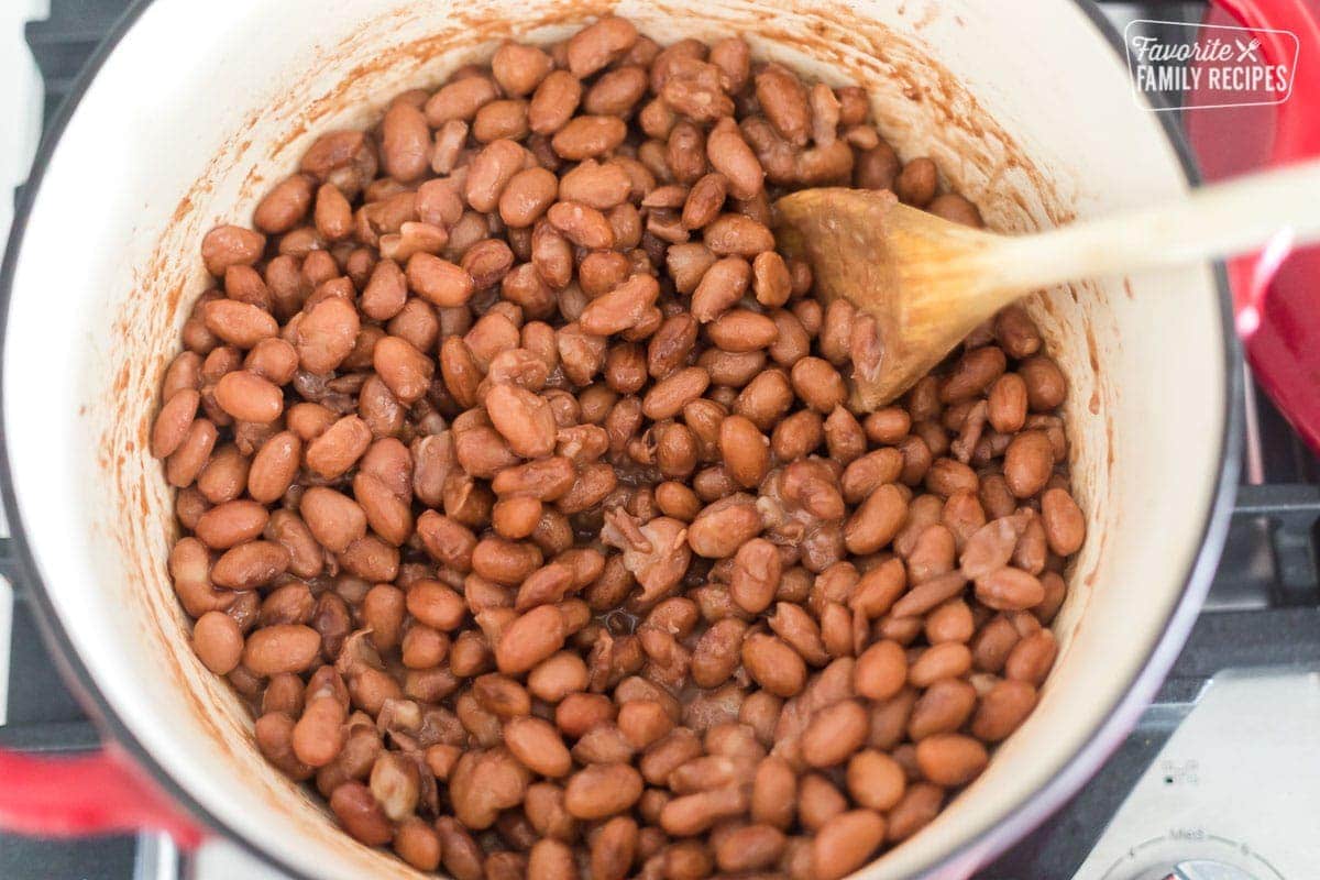 A ceramic Dutch oven with refried beans cooking down.