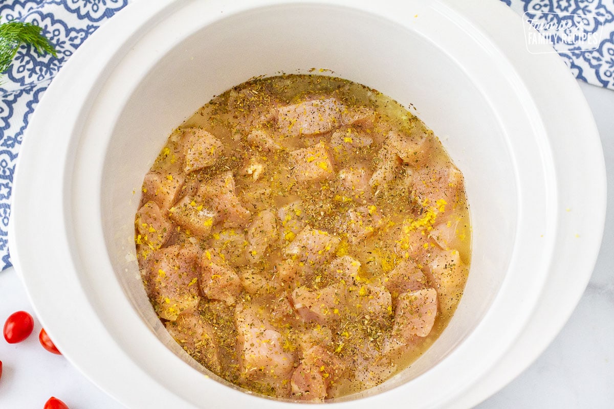 Seasoning on top of chicken in a crockpot for Chicken Gyro.