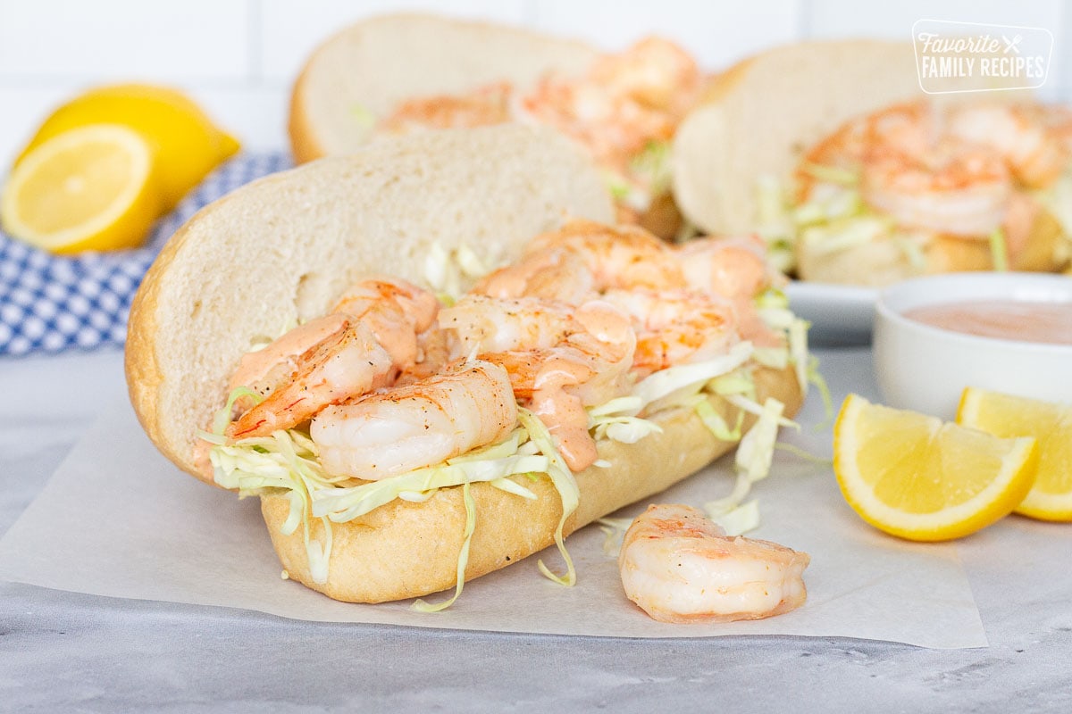 Shrimp Po'Boy Sandwiches with cajun sauce and lemon wedges.