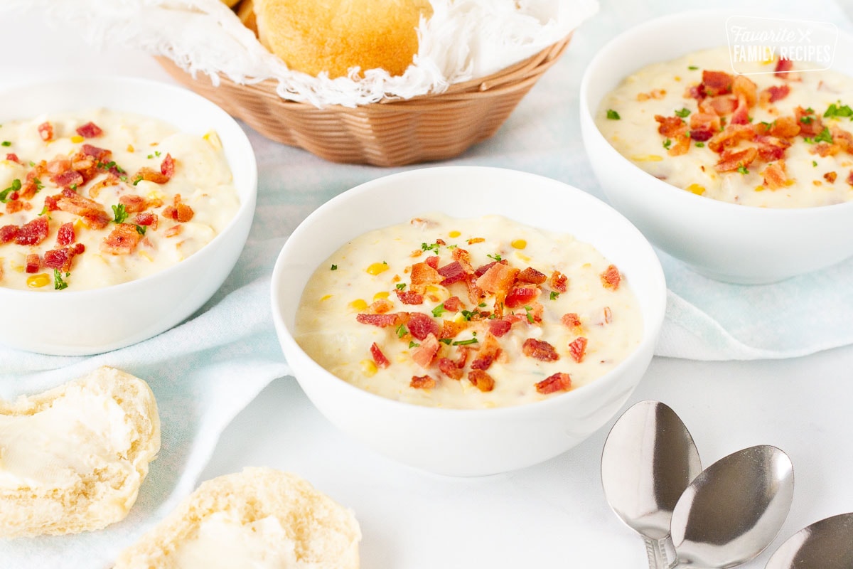 Three bowls of Corn Chowder with Bacon soup garnished with bacon and parsley.
