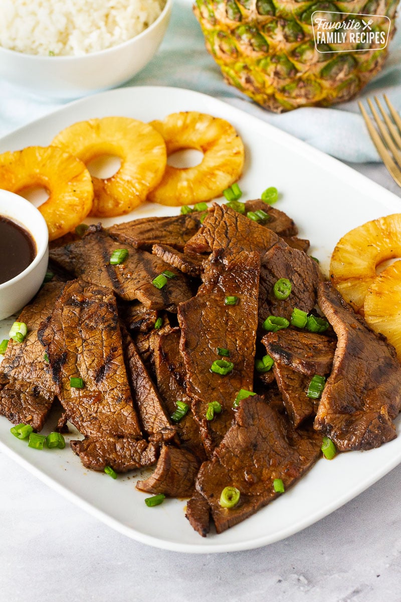 Plate of Hawaiian Beef Teriyaki with pineapple and sauce. Garnished with green onions.