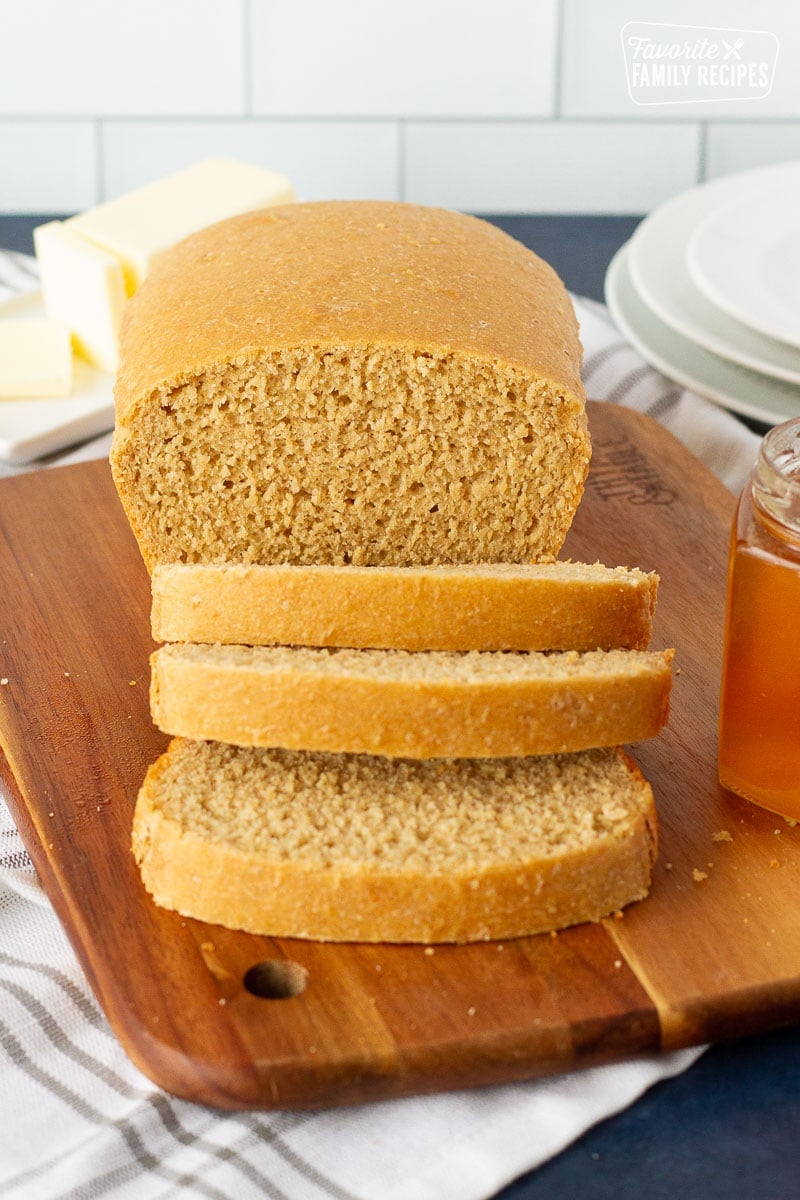 Loaf of Honey Whole Wheat Bread sliced on a cutting board.