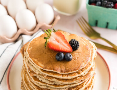 A stack of sourdough pancakes topped with berries