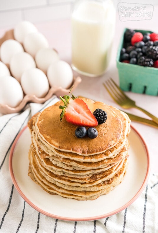 A stack of sourdough pancakes topped with berries