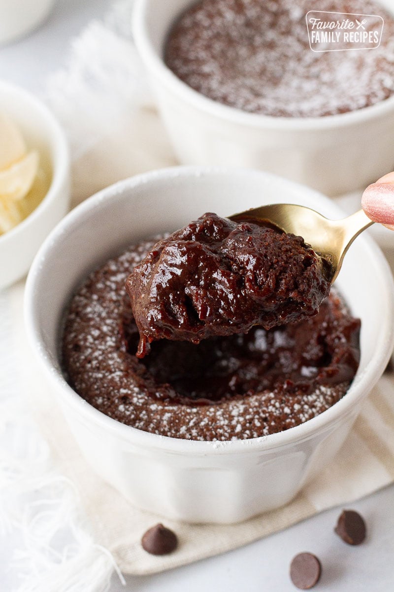 Hand holding a spoon with gooey Carnival Cruise Melting Chocolate Cake.