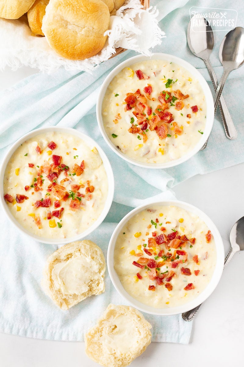 Three bowls of Corn Chowder with Bacon garnished with bacon and parsley.