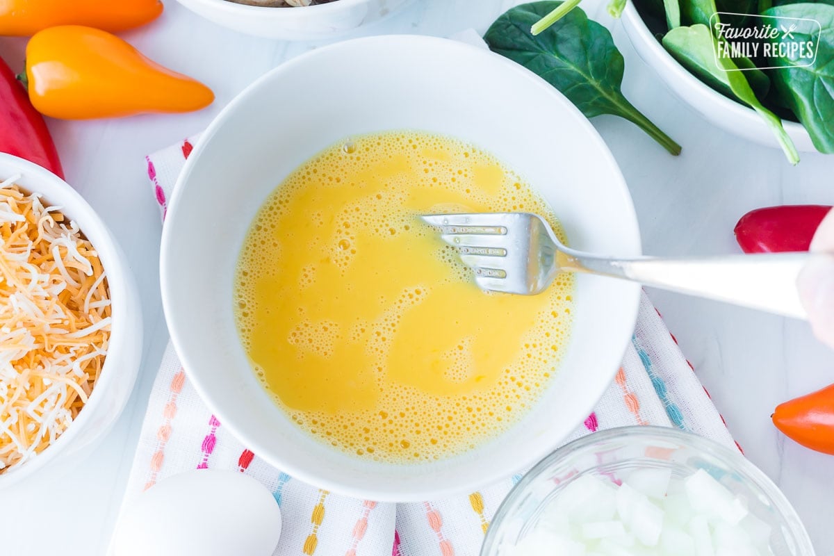 Close up of beaten egg in a white bowl