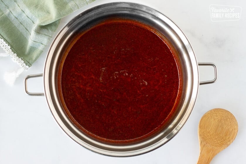 Pan of Homemade Enchilada Sauce base next to a wooden spoon.