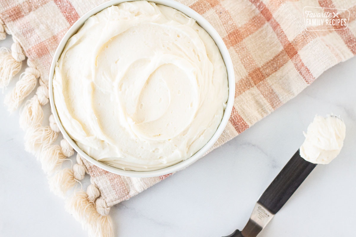 Bowl of Cream Cheese Frosting next to a spatula with Cream Cheese Frosting.