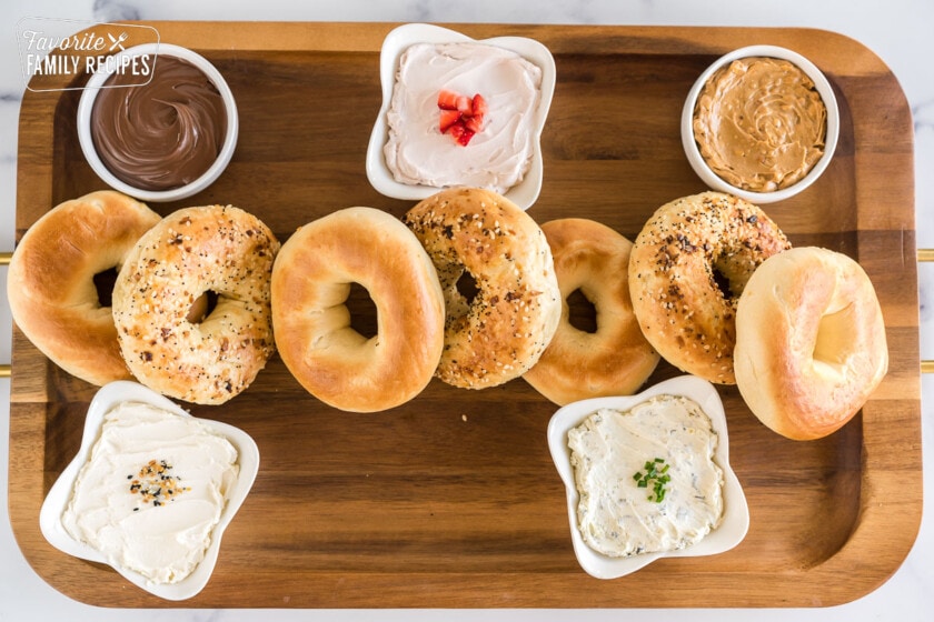 bagels and spreads on a large wooden board