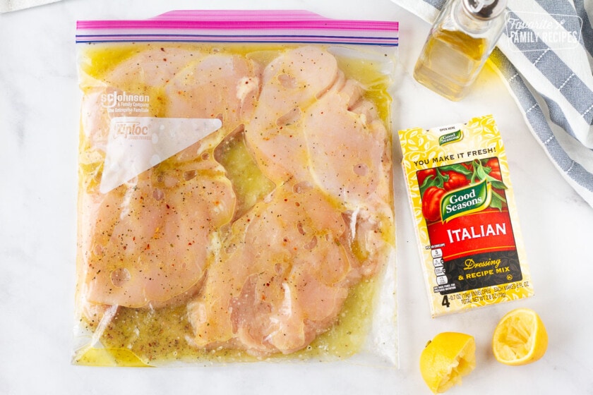 Bag with marinating chicken breasts. Italian dressing mix, olive oil and lemons on the side for Grilled Chicken Sandwiches.
