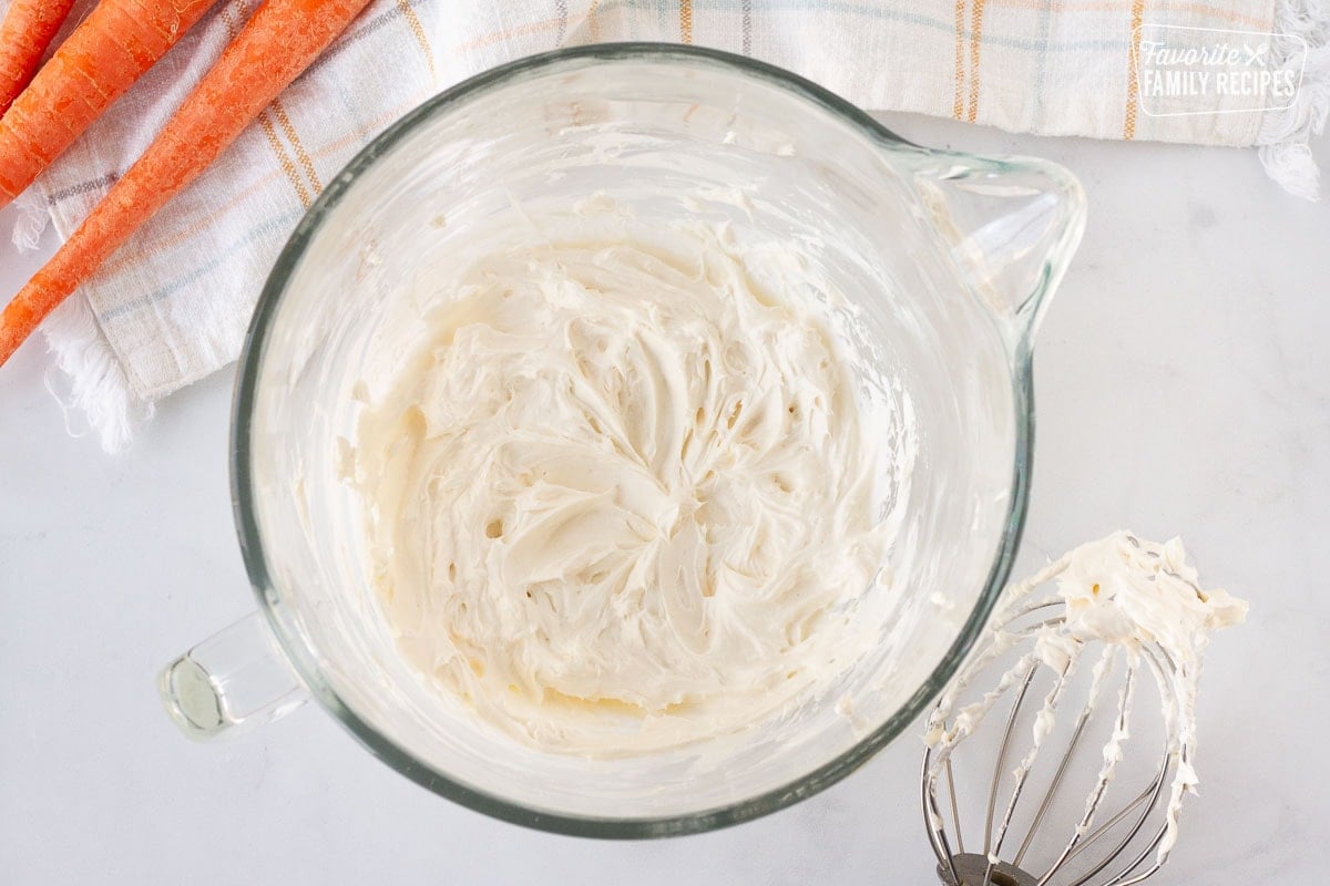 Mixing bowl with cream cheese and butter blended for cream cheese frosting on Carrot Cake Cookies.