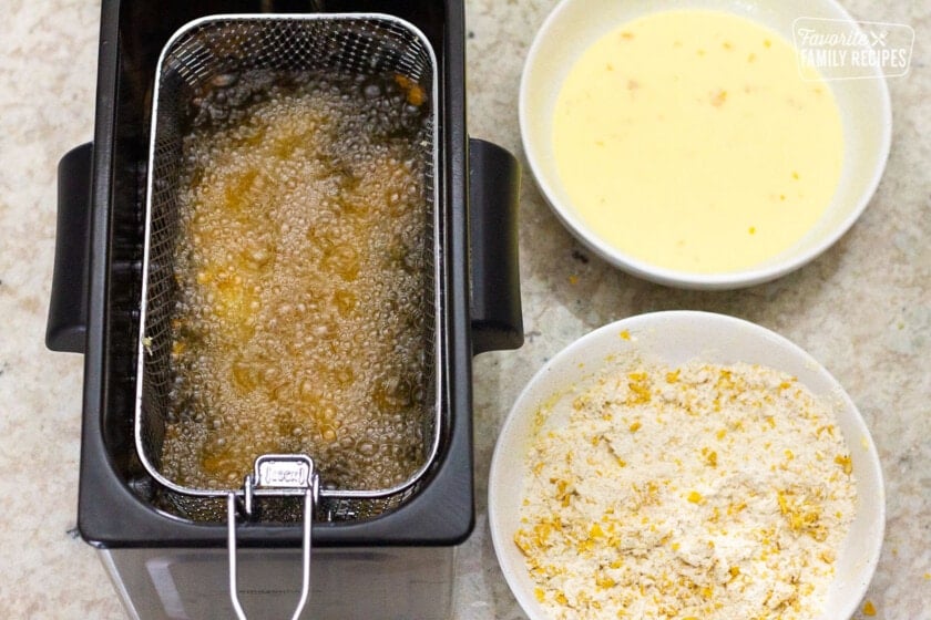 Frying chicken in a deep fryer for Applebee's Oriental Chicken Salad.