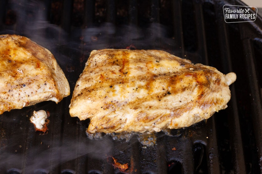 Grilling Chicken breasts on a bbq for Chicken Pesto Sandwiches.